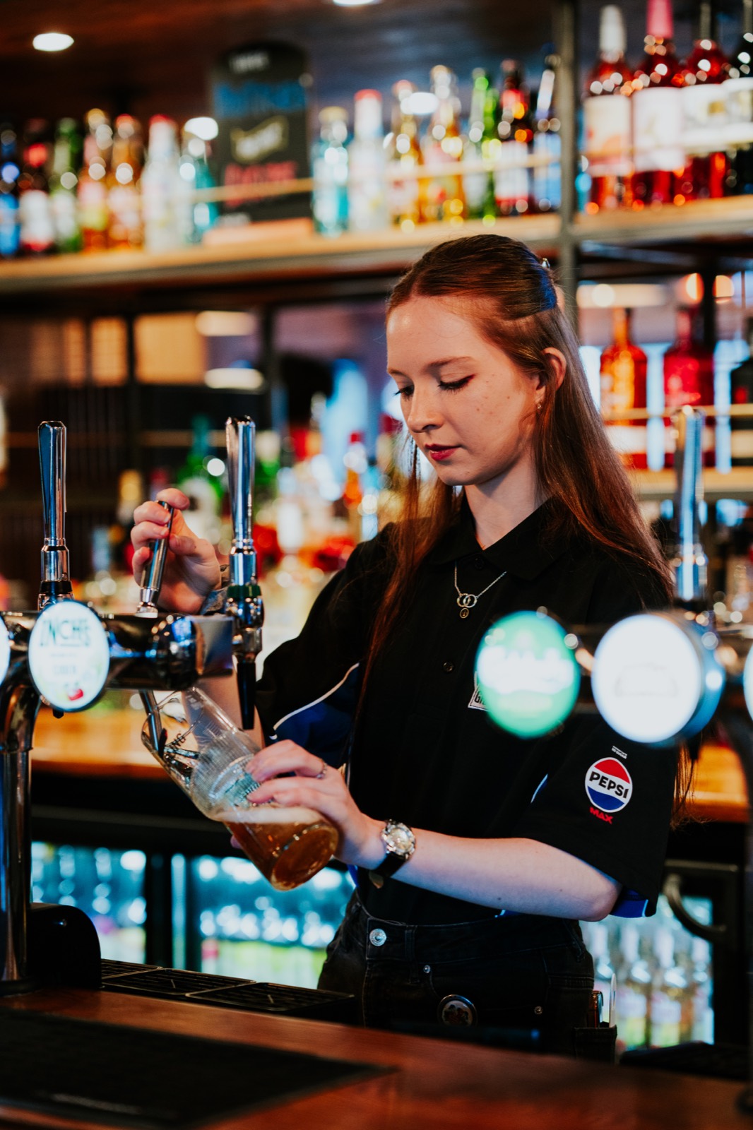 A bartender pouring a pint in a Grandstand pub
